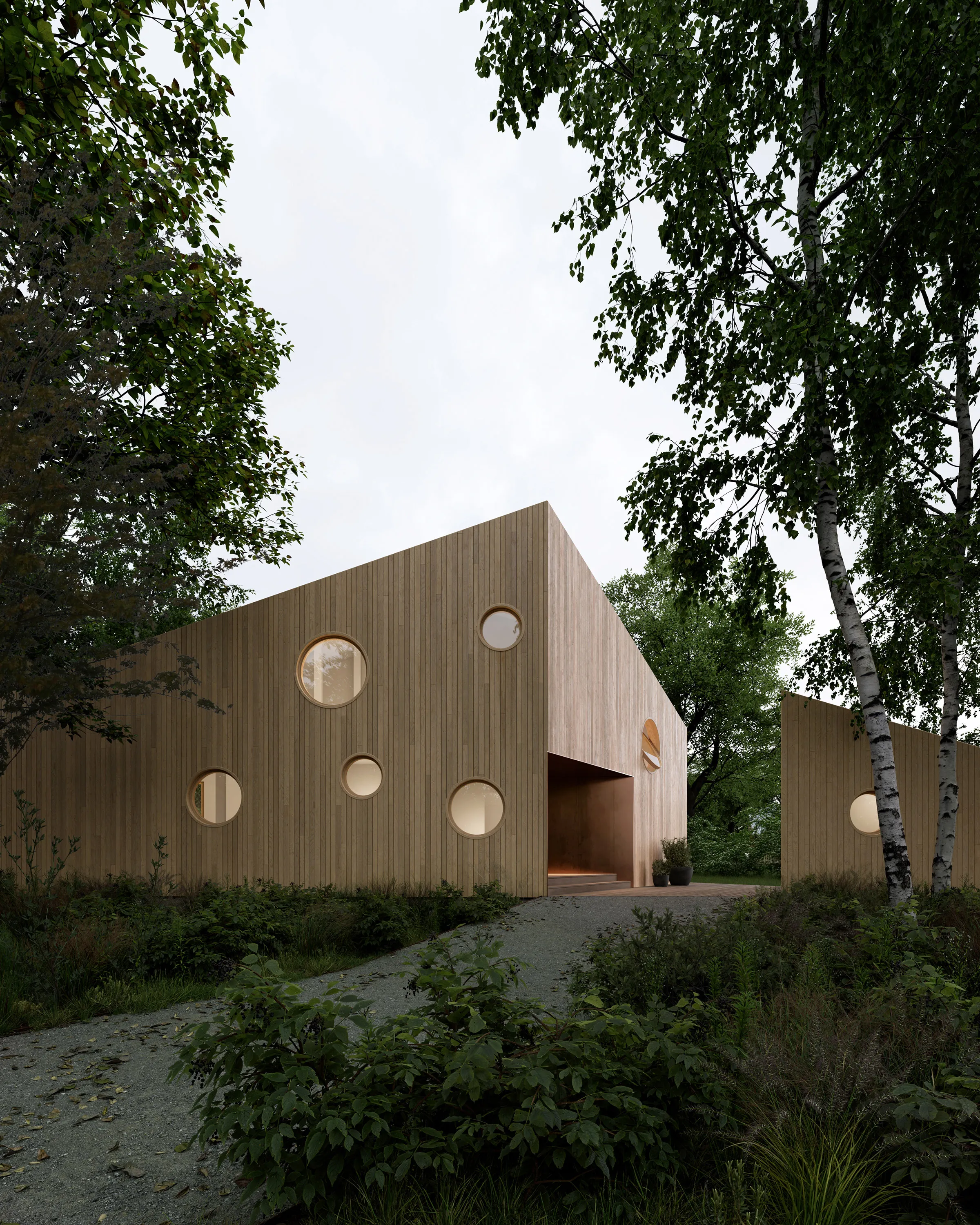 Entrance side of the Wing House at dusk, its timber facade punctuated by circular windows above a gravel path.